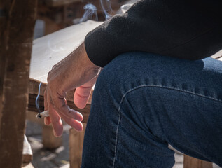 male hand holding a cigarette.