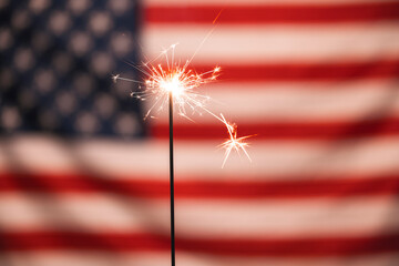 Sparkler with the USA United States flag on the background for the Fourth of July celebration