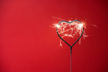 Valentine's Day heart shape sparkler with a red background during the month of February where...