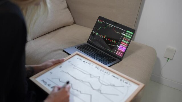In the midst of cryptocurrency trading, a girl meticulously takes notes. A focused journey into the dynamic world of digital finance. Woman focus studying bitcoin and ethereum.