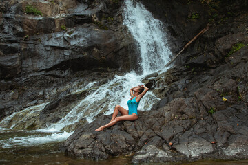 Beautiful Young Woman in Swimsuit Posing Near Waterfall