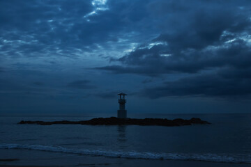 Beautiful View of Lighthouse on Rocky Island in the Sea During Dusk with Dramatic Clouds