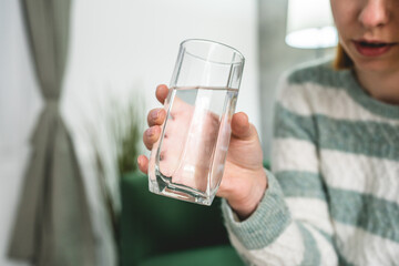 close up on midsection of unknown caucasian woman hold glass of water