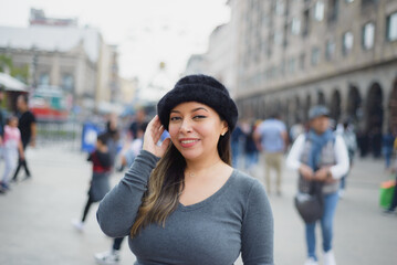 Latina woman with positive attitude in the middle of the street. People in background.