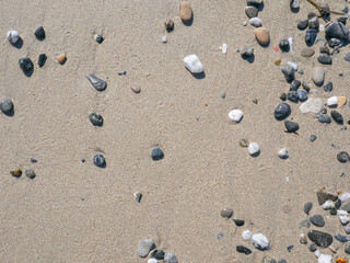 Fototapeta na wymiar Background of colorful pebbles on the sand beach