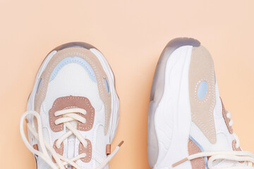 Pair of stylish sneakers on a brown background close-up top view.