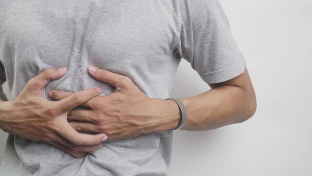 Sick Asian man experiencing stomach ache, pain and discomfort, severe abdominal pain, left kidney infection or appendicitis, pain in the left side of the stomach instead of the right