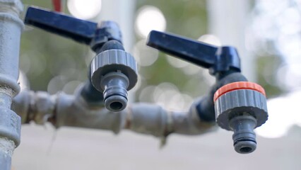 Low angle view of water hose faucets for household usage or irrigation system, external faucets being used with long hoses for agricultural watering