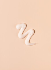 cosmetic smear of creamy texture on a beige background
