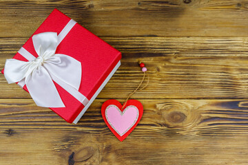 Gift box and red heart on a wooden background. Valentine's Day concept