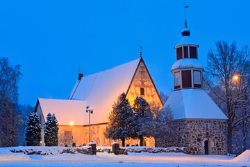 A medieval church illuminated in winter evening 