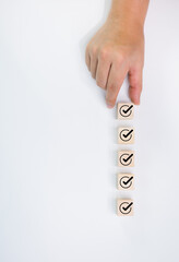 Businessman places correct marking wooden blocks next to each other for quality document checklist and business approval project concept.
