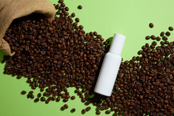 Creative background for advertising with white empty bottle displayed on coffee beans and green background. Top view. Coffee contains antioxidants that can help protect against UV ray