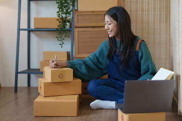 Fototapeta na wymiar Asian female business owner handles delivery of orders to customers