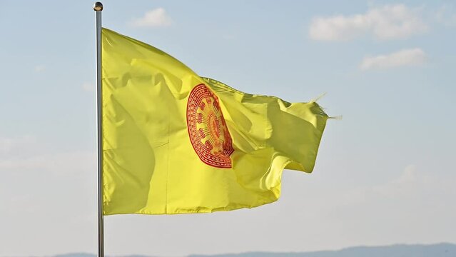 Thai Buddhist flag blowing by the wind. The red circle is a dharma wheel (dhammachak in Thai) and it represents dharma, the teachings of the Buddha.
