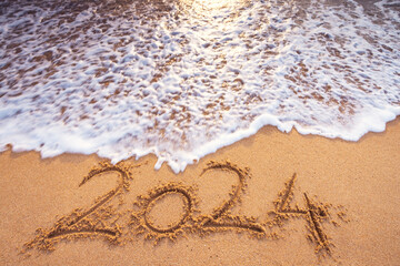 Seascape nature background of sea wave, beach sand and text 2024 happy new year