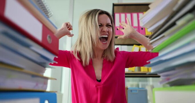 Businesswoman screaming and pulling out hair near many folders with paper documents 4k movie slow motion