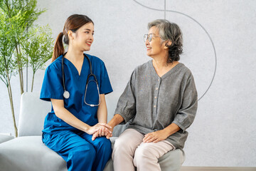 Young asian female doctor or nurse happily supports elderly patients, Woman doctor therapist sit on...