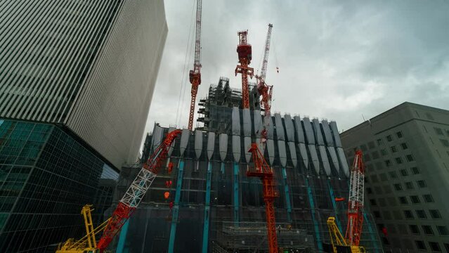 Timelapse of towering cranes at building construction site in Tokyo, Japan