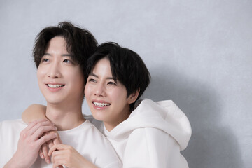 リンクコーデで寄り添う笑顔のカップルのクローズアップ 　見上げる