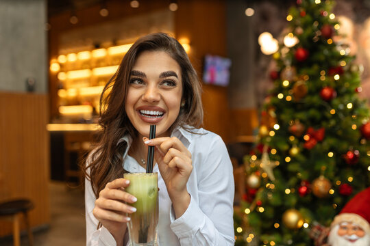 Cute young woman taking a smoothie break at a juice bar, Cheerful young woman having lunch and healthy smoothies at a juice bar
