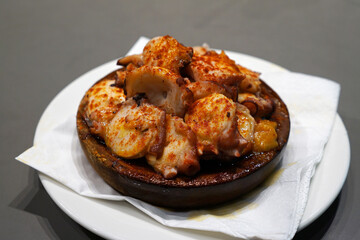 Close up Pulpo a la Gallega or Pulpo a Feira, Galician style steamed octopus in olive oil and paprika powder- Classic Spanish Tapas