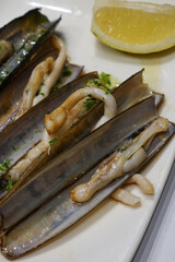 Close up Receta de navajas a la plancha, Razor Clams with Chiles, Garlic and olive oil- Classic traditional Spanish tapas