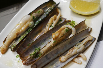 Close up Receta de navajas a la plancha, Razor Clams with Chiles, Garlic and olive oil- Classic traditional Spanish tapas