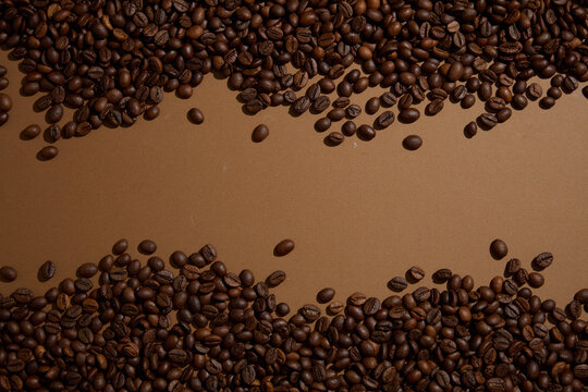 Mockup scene for advertising organic cosmetic with ingredient from coffee. Many coffee beans are displayed filling the top and bottom edges of the frame, creating space in the middle for the design © Tuan Nguyen 