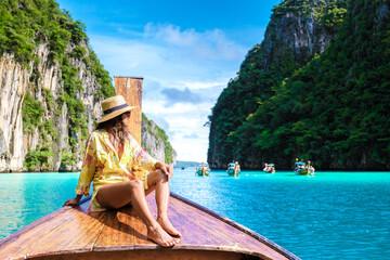 Asian women in front of a longtail boat at Kho Phi Phi Thailand - obrazy, fototapety, plakaty