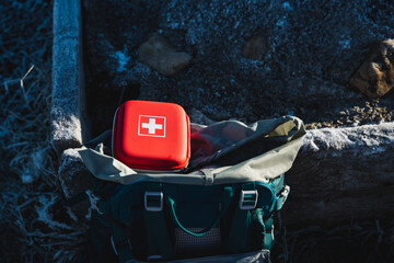 The red box of the first aid kit with medicines is in the backpack of the tourist, essential...