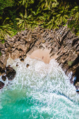 A couple of men and women relaxing on a white tropical beach with palm trees in Phuket Thailand