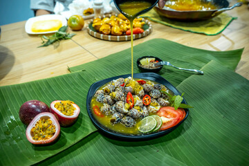 Babylonia areolata shellfish seafood on bowl served with passion fruit sauce ready for eat