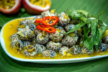 Steamed Spotted Babylon Blanching (Fresh Sea Babylonia Areolata Shell Boiled) served with passion fruit sauce goodtasty decorated with spices side view