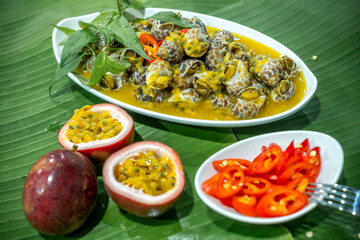 Steamed Spotted Babylon Blanching (Fresh Sea Babylonia Areolata Shell Boiled) served with passion fruit sauce goodtasty decorated with spices side view