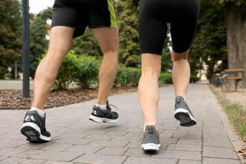 Fototapeta premium Healthy lifestyle. Couple running in park, closeup