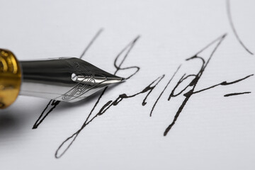 Signing on sheet of paper with fountain pen, closeup