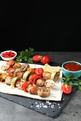 Delicious shish kebabs served on grey table, closeup