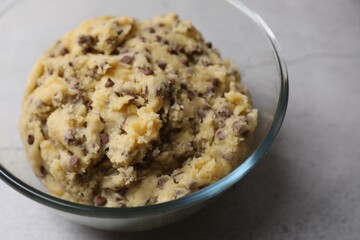 Chocolate chip cookie dough in glass bowl on table, closeup