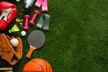 Naklejka premium Different sport equipment on green grass, flat lay. Space for text