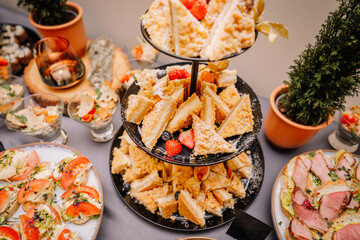 appetizing appetizers presented at a catering event. A variety of dishes are neatly arranged on the buffet table, showcasing a range of colors and textures.