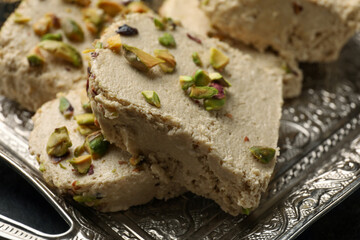 Tray with tasty pistachio halva on table, closeup