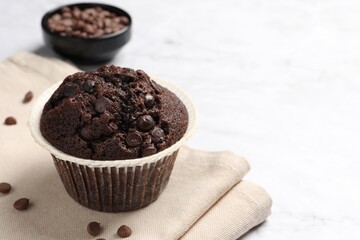 Tasty chocolate muffin on white table, closeup. Space for text