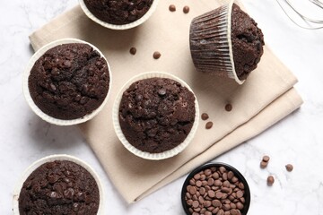 Tasty chocolate muffins on white marble table, flat lay