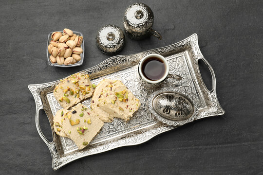 Tasty halva with pistachios served on grey table, flat lay