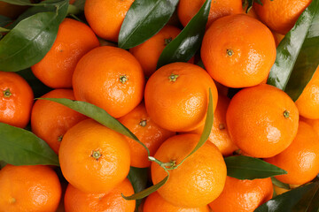 Delicious tangerines with leaves as background, top view