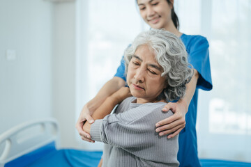 senior woman doing exercise at clinic with physiotherapist. help of a personal trainer during a...