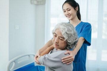 senior woman doing exercise at clinic with physiotherapist. help of a personal trainer during a...