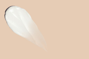 smears of cosmetic cream on a beige background.