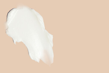 smears of cosmetic cream on a beige background.